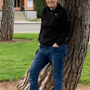 Photo of Shannon Whitmore leaning against a tree.