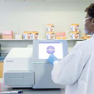 Female lab scientist working with an Illumina gene sequencing machine.