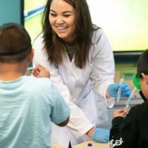 Illumina scientist working with children in a classroom.