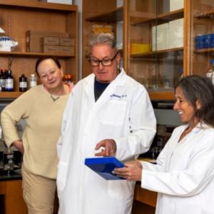 Drs. Johnston and Mandel with a box containing microscope slides for pathology samples. 