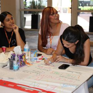 Students work together on a "Create Your Own Festival" exercise, organizing ideas with sticky notes and shared worksheets.