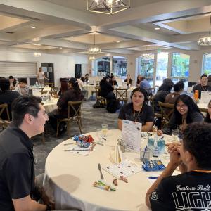Students and industry professionals participate in a roundtable networking discussion during a career development event.