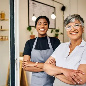 Two people smiling, standing with arms crossed