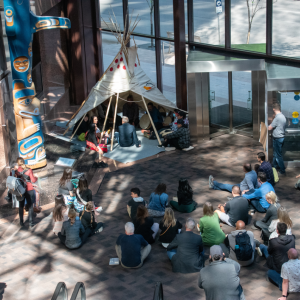 People seated in and around a teepee