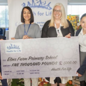 Students and teachers holding a cheque 
