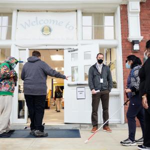 students using white canes entering a school building