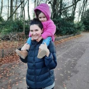 Cécile Vivares with her daughter who is riding on her shoulders.