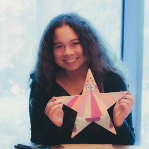 Young woman holding up painted star