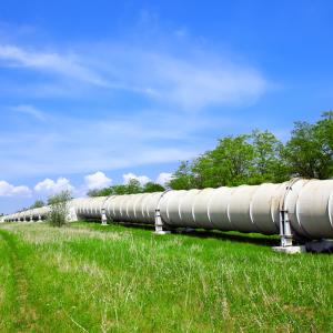 Pipeline in a grassy field with a blue sky