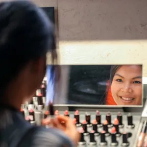Person applying makeup in a mirror