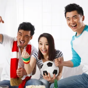 3 people celebrating while watching sports at home