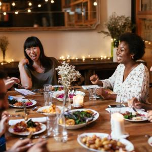 group of people laughing and talking over dinner