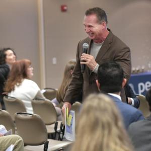 A person talking in front of an audience 