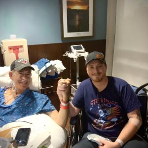 Two people clasping hands from a hospital bed