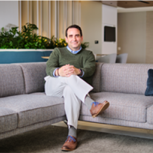 Person with hands and legs crossed on a couch