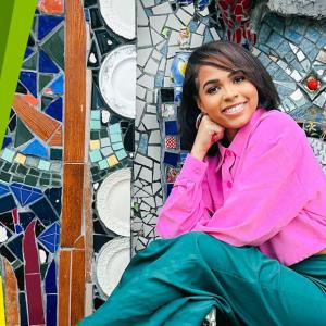 Jordyn Wright posed in front of a mosaic mural.