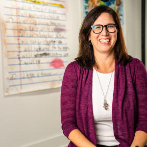 Person sat smiling with art behind them