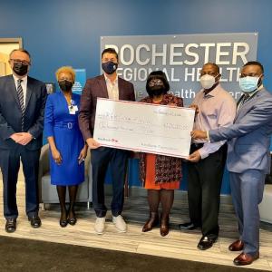 Rochester Regional Health accepts check for $100,00 from KeyBank. 