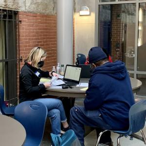 KeyBank volunteer seated with a individual and helping him prepare his tax return. 