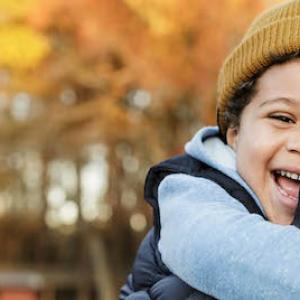 Man pictured with his son in front of a fall foliage scene.