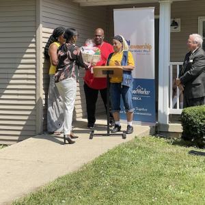 Photo: Cynthia and Larry Robinson are presented with gifts to celebrate their first home, financed by new loan program in city of Toledo.
