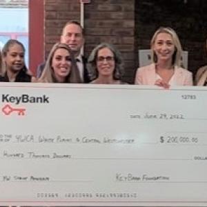 Group of people hold a large KeyBank check
