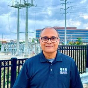 Seemesh M. Sethi outdoors, power lines behind them.