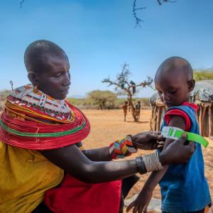 Rashei's mother checks his MUAC measurement after treatment. 