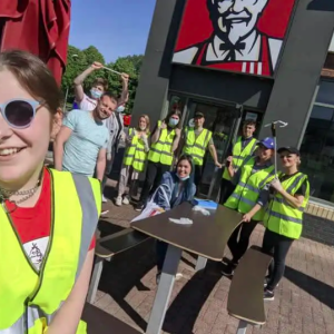 KFC employees in hi-vis vests cleaning up litter