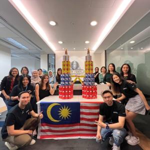 Group posing by two pyramids of cans