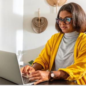 Kat Hernandez sitting, working on a laptop