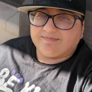 Kay wearing a Pride baseball hat.