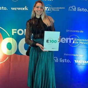 Karla Huerta holding a "E100" award.