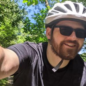 Kevin Arritt shown on a bicycle and wearing a helmet.