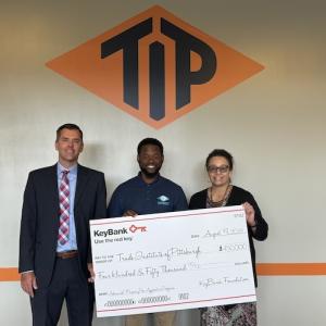 KeyBank and representatives from TIP shown holding a $450,000 grant check.