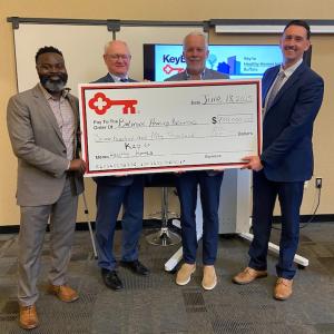 Representatives from KeyBank and Belmont Housing Resources shown with a $750,000 grant check.