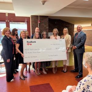 Group of people hold a large KeyBank check