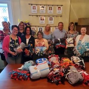 KeyBank volunteers pictured with blankets that they have assembled.