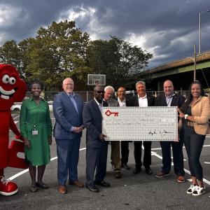 Representatives from KeyBank and Excelsior University shown with a check.