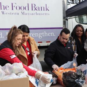 KeyBank volunteers working with The Food Bank volunteers preparing food bags.
