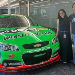Kim shown in front of a bright green race car.