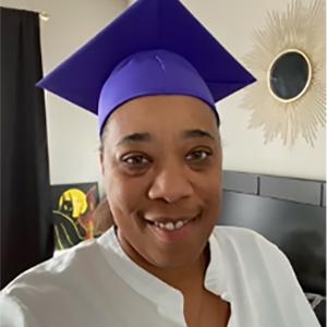 Kim E. in a graduation cap