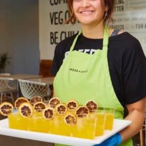 Kimberly Hoffmann wearing an apron, holding a tray of drinks.