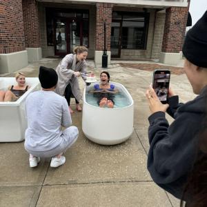 Kimberly Hoffmann and another in tanks of water outside a building "Yoga on the Lake".
