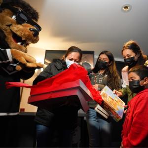 LA Kings mascot Bailey unwraps presents with families in the arena suite at Crypto.com Arena (formerly STAPLES Center).
