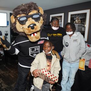 LA Kings mascot Bailey poses with families during the LA Kings Adopt-A-Family event at Crypto.com Arena (formerly STAPLES Center).