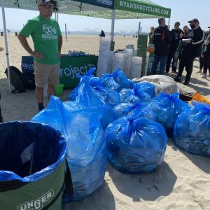 people picking up trash along a beach