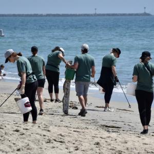 people picking up trash along a beach