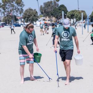 people picking up trash along a beach