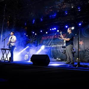 Two people on a stage playing guitars